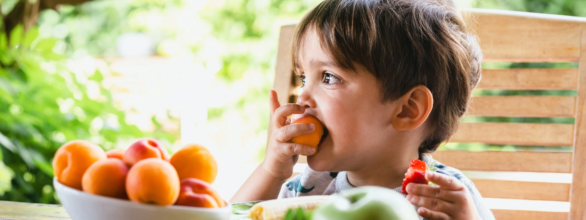 Criança comendo fruta